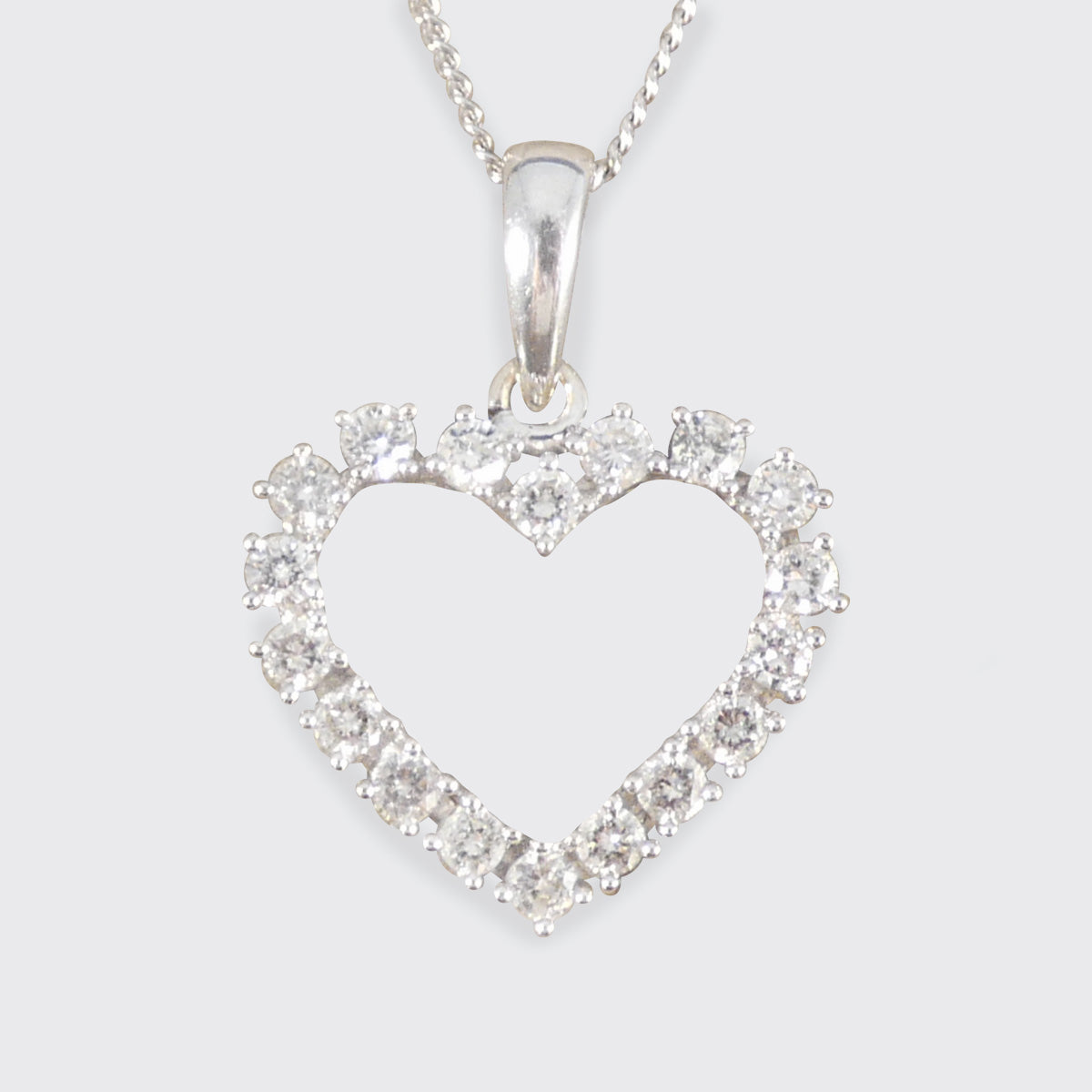 Heart-shaped 18ct white gold pendant with diamonds on a white background