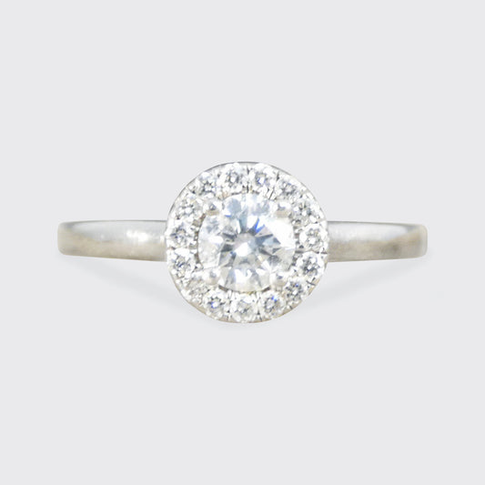 Diamond ring with a halo on a light gray background
