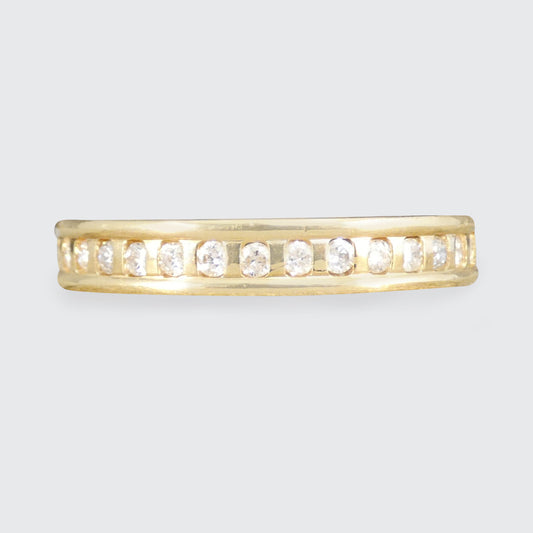 Gold ring with embedded diamonds on a light gray background