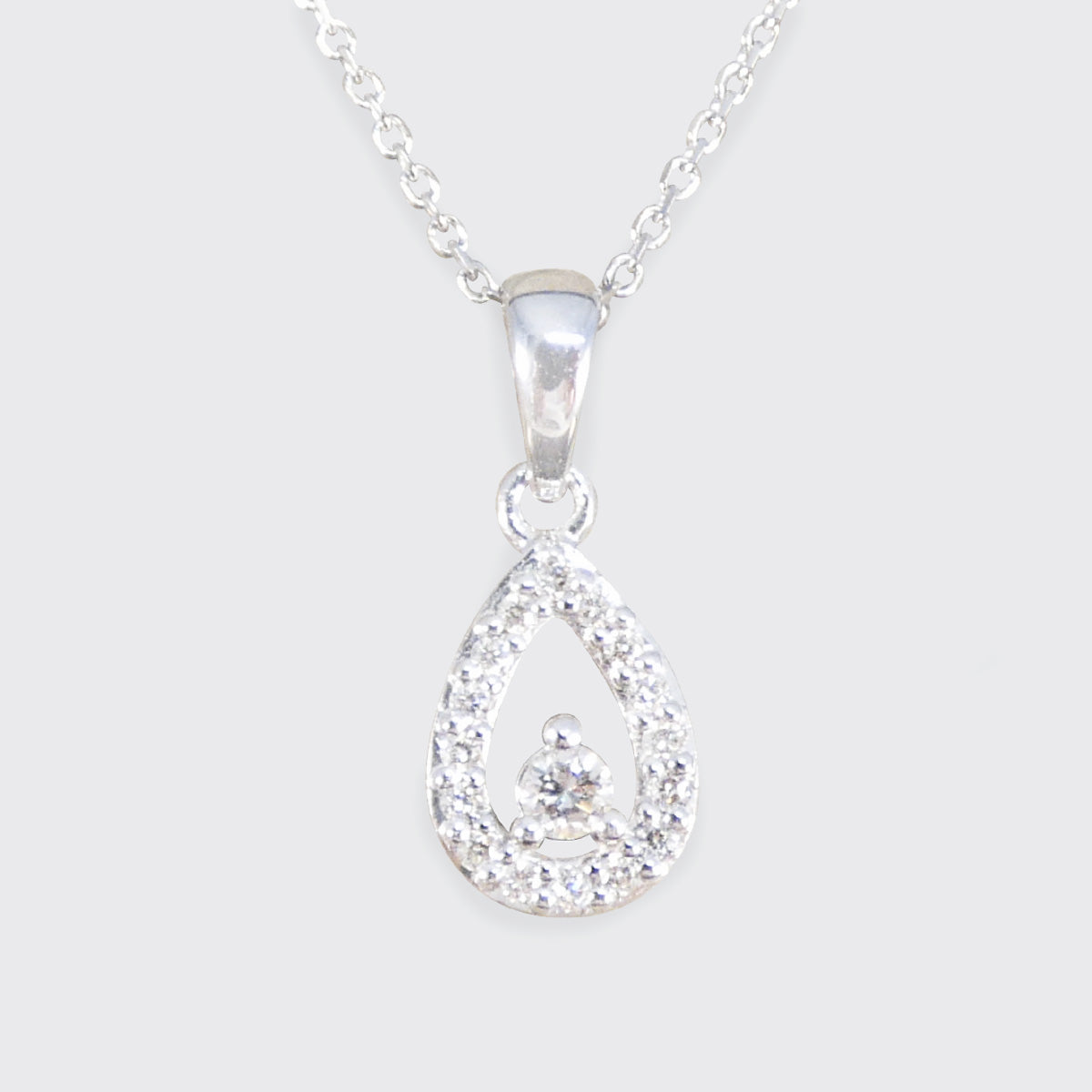Teardrop shaped diamond cluster necklace in white gold.