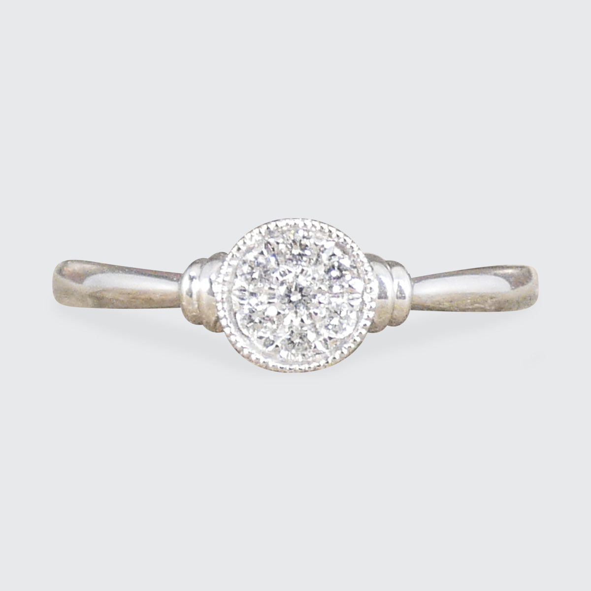 A diamond set disc shaped cluster ring with a double donut shoulders in Platinum.