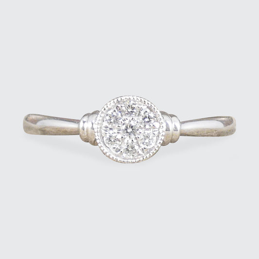 A diamond set disc shaped cluster ring with a double donut shoulders in Platinum.