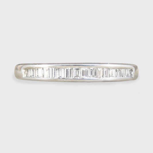 Diamond ring with baguette cut stones on a light gray background