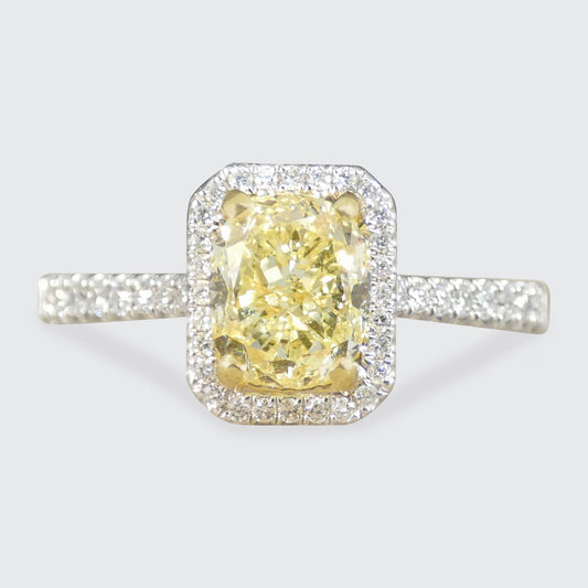 Diamond ring with a yellow gemstone on a light gray background