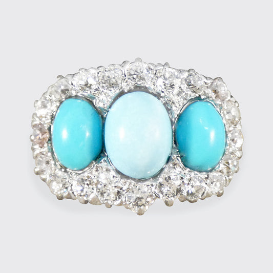 Jewelry with three turquoise stones and a central light blue stone, surrounded by clear stones on a white background.