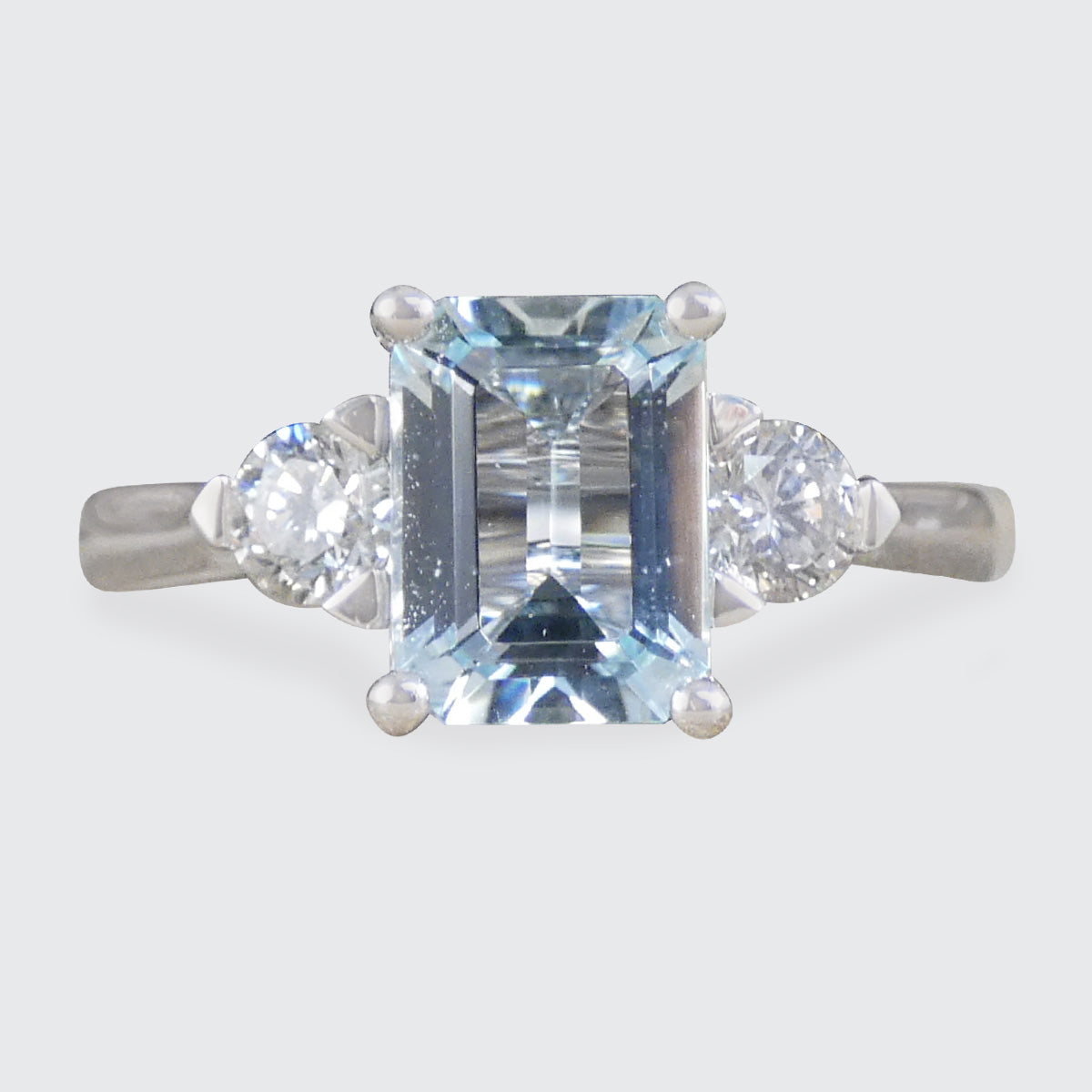 Modern Emerald Cut Aquamarine and 0.35ct Diamond Three Stone Ring in Platinum.