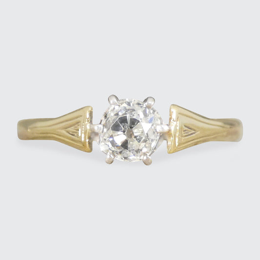 Gold ring with a diamond on a light gray background