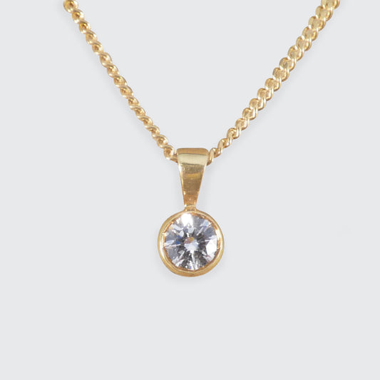 Classic solitaire diamond pendant necklace in 18ct yellow gold, featuring a brilliant-cut diamond in a sleek bezel setting on a curb chain.