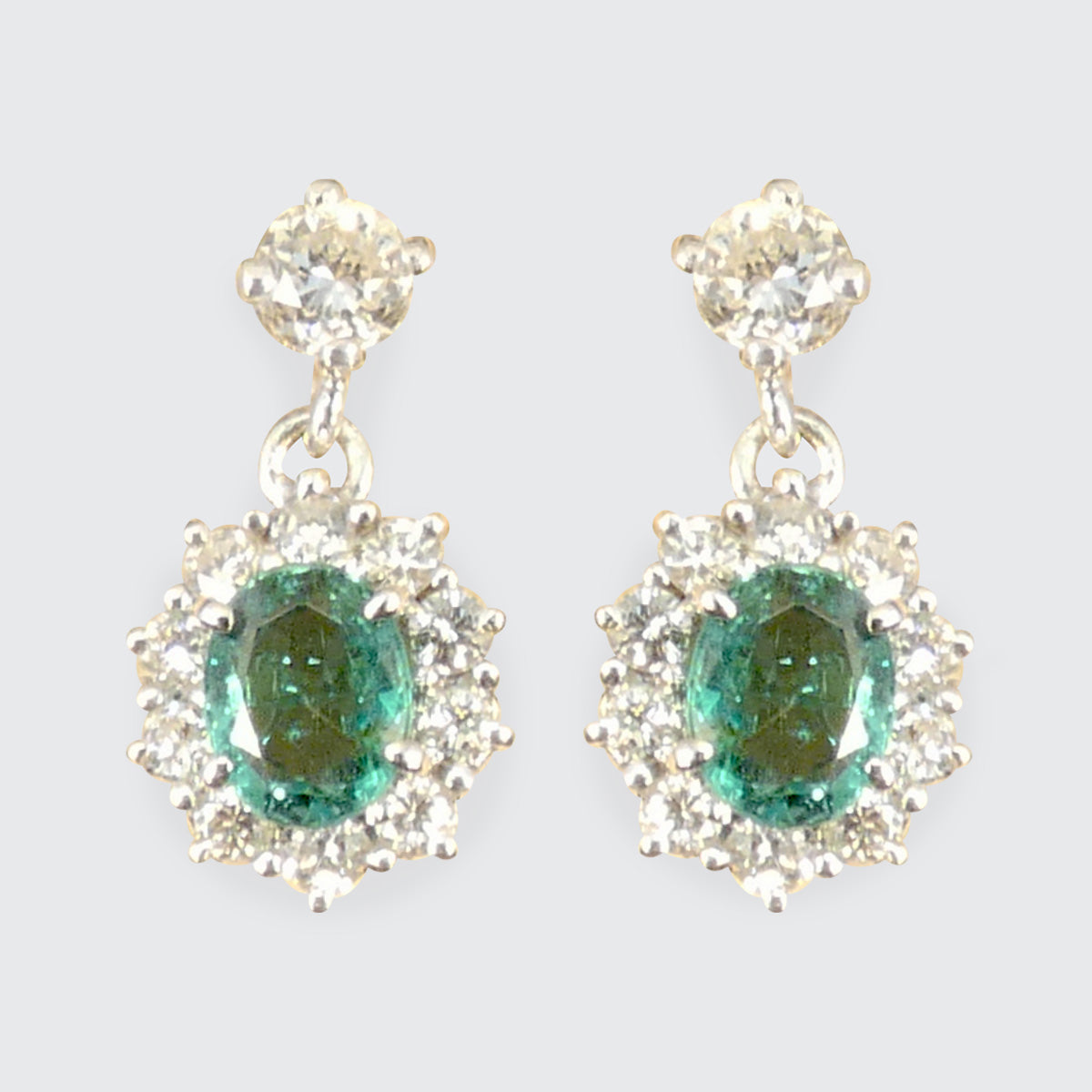 A pair of Emerald and Diamond cluster drop earrings with clear and bright diamonds.