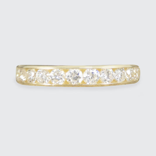 Gold ring with diamonds on a light gray background