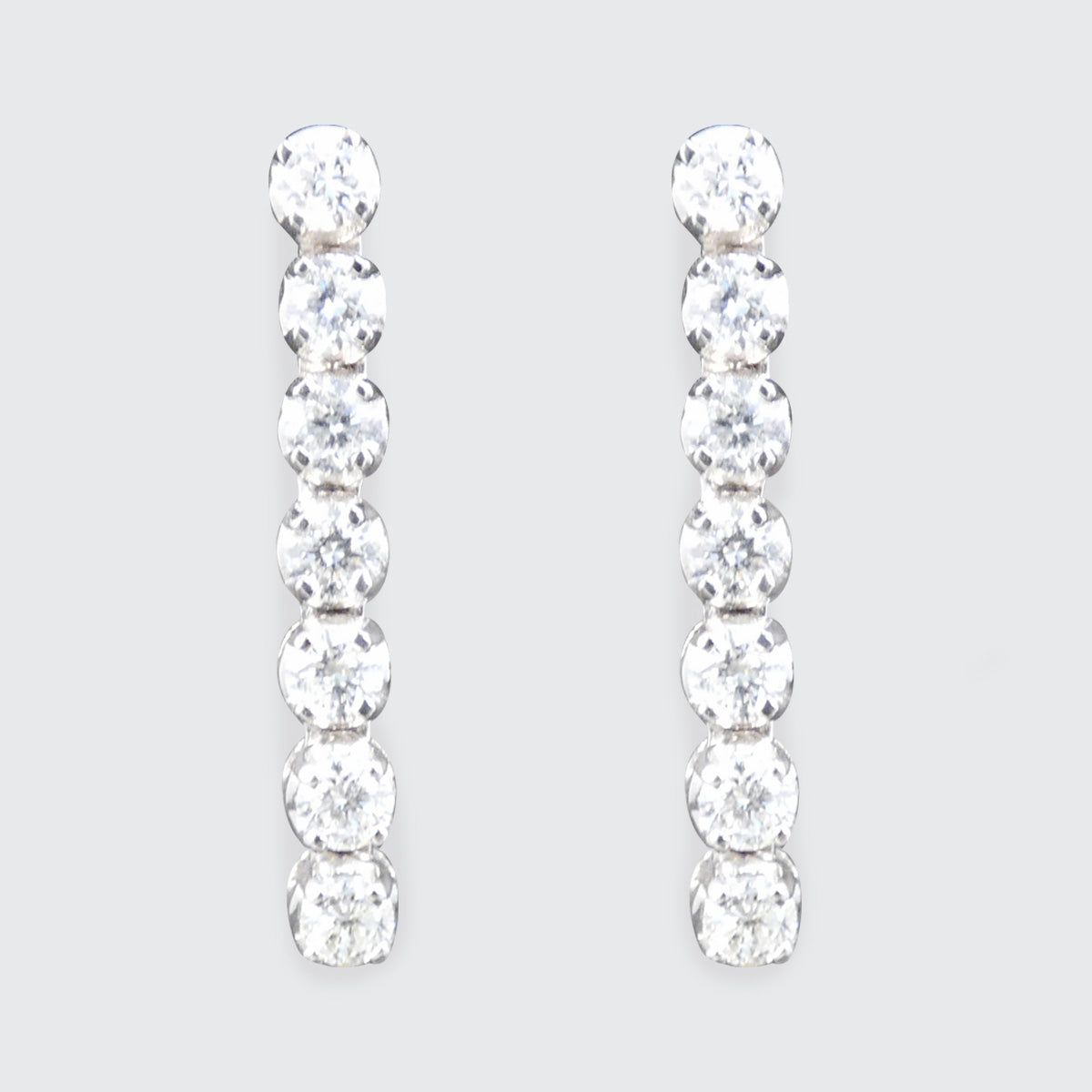 Pair of diamond earrings on a light gray background