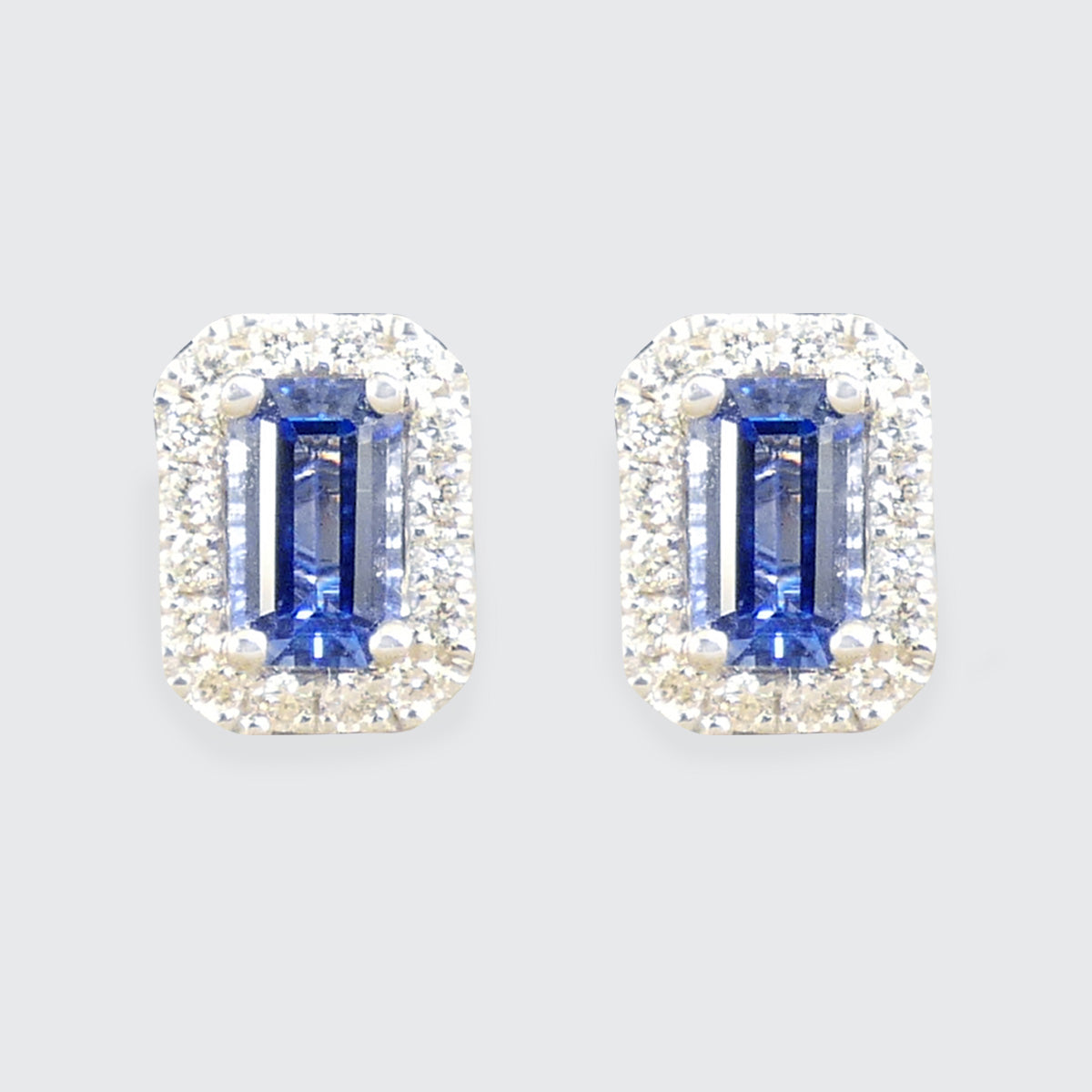 A bright and vibrant pair of Sapphire and Diamond Halo Cluster Stud Earrings in 18ct White Gold.