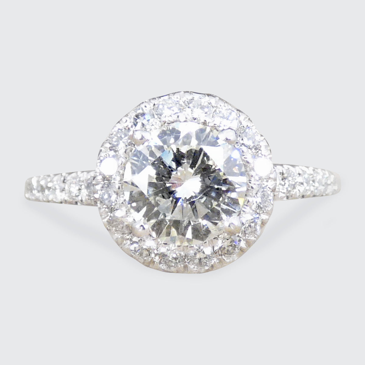 Diamond cluster ring with a diamond shoulders on a light gray background