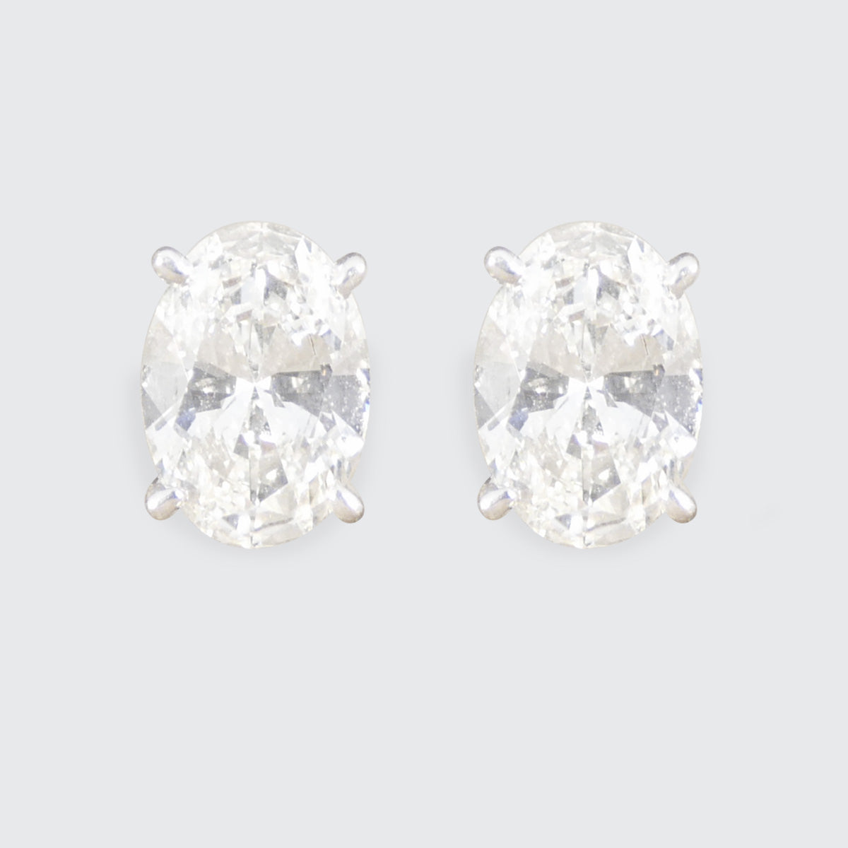 Pair of diamond stud earrings on a light gray background