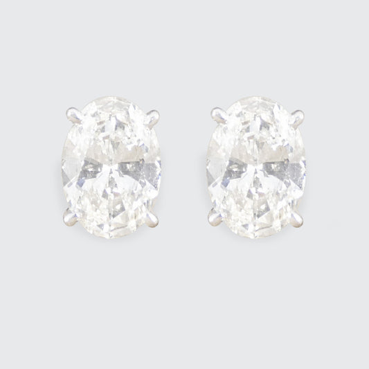 Pair of diamond stud earrings on a light gray background