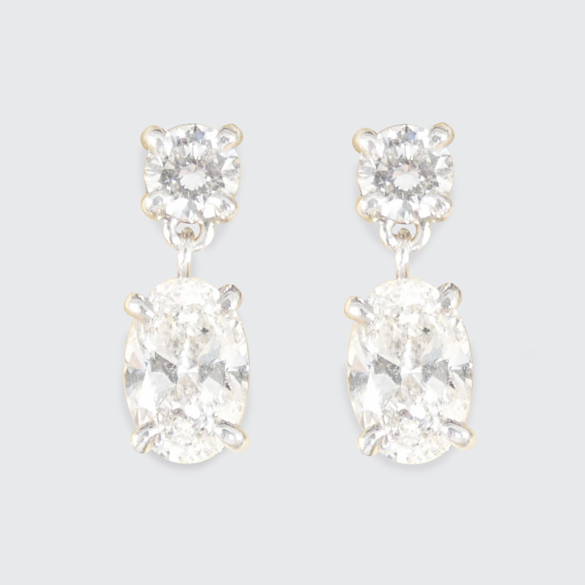 Pair of diamond earrings on a light gray background