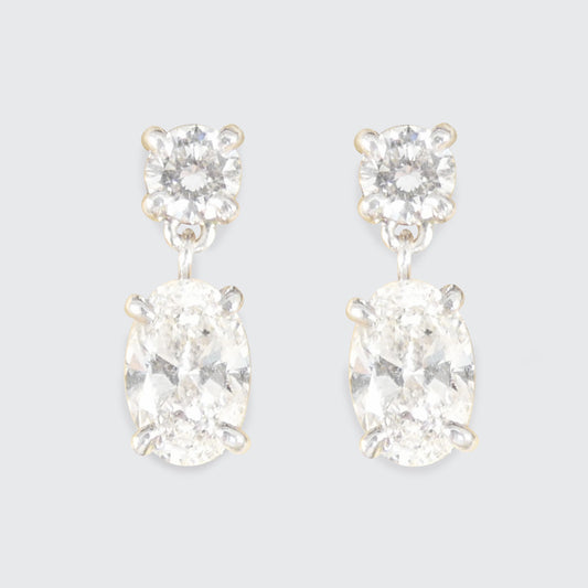 Pair of diamond earrings on a light gray background