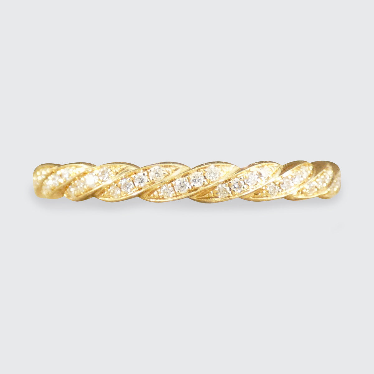 Gold ring with diamond accents on a light gray background