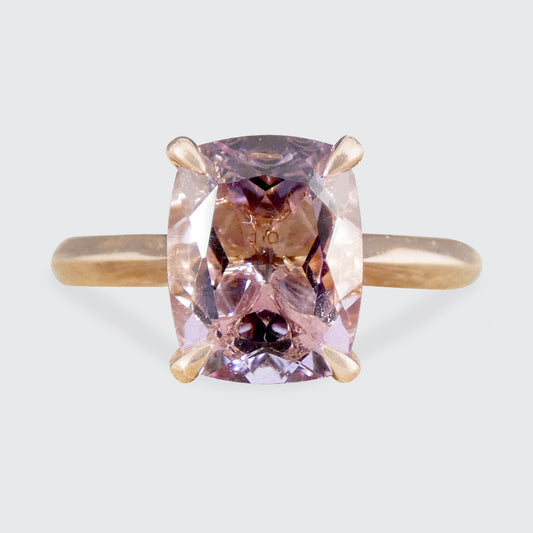 Ring with a pink gemstone on a light gray background