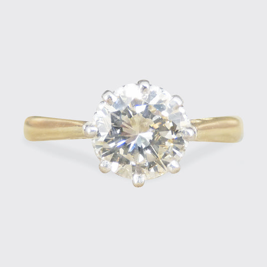 Gold ring with a large diamond on a light gray background