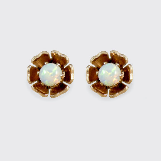 Pair of flower-shaped earrings with opal stones on a white background