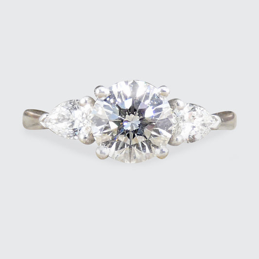 Diamond ring with a three gemstones on a light gray background