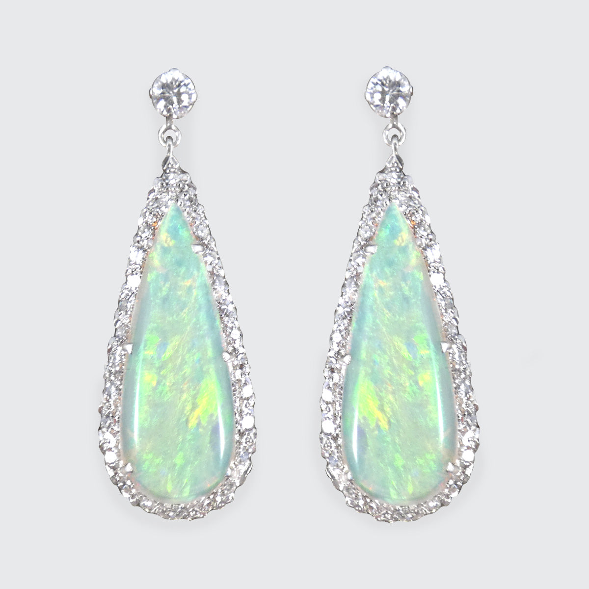 Vintage opal and diamond cluster drop earrings set in platinum, featuring luminous opal centres surrounded by sparkling diamond halos and elegant drop settings.