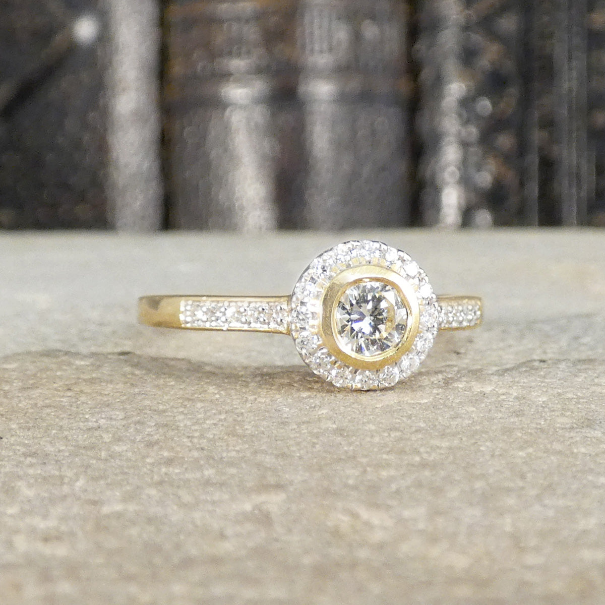 Diamond halo cluster ring in 18ct yellow gold with diamond set into each shoulder.