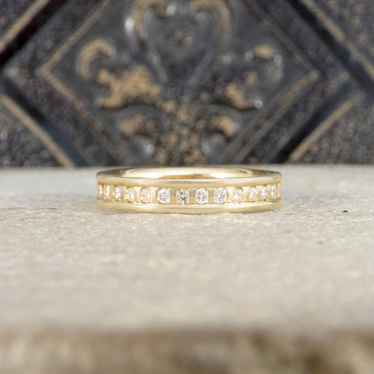 Gold ring with diamonds on a textured surface