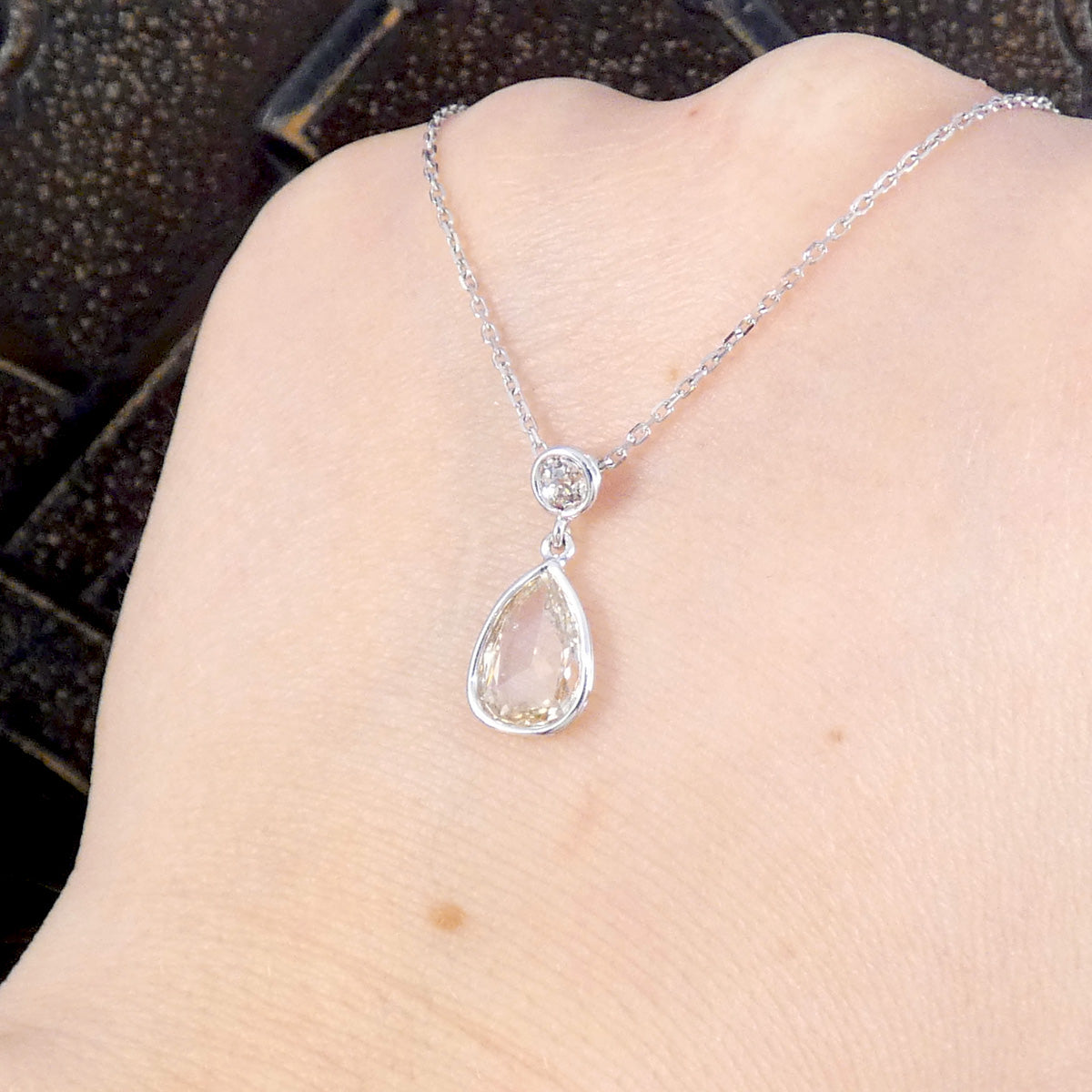 Unique modified rose cut Diamond and brilliant cut drop necklace in 18ct White Gold. Shown on the hand to see how transparent the Diamond is showing skin colour through.