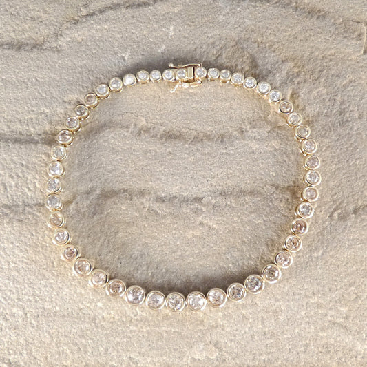 a full diamond set tennis bracelet in a rub over bezel setting.