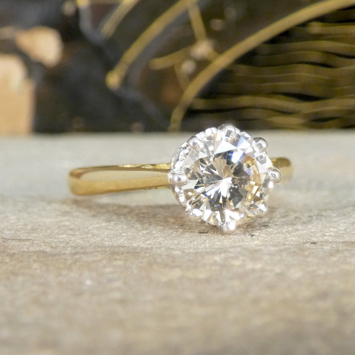 Gold ring with a large diamond on a textured surface