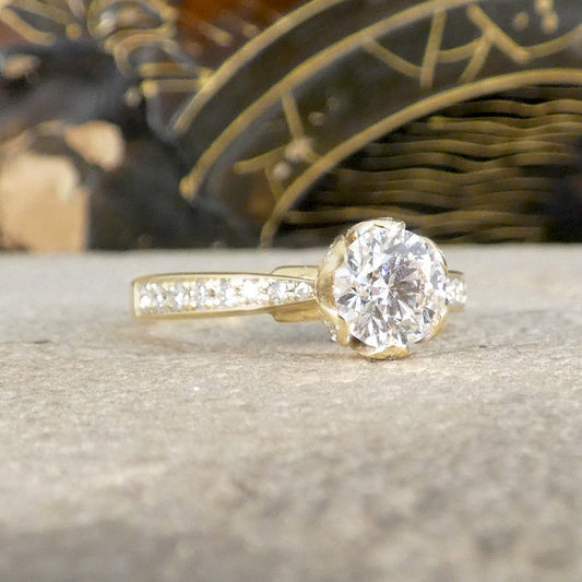 Gold diamond ring on a textured surface with a blurred decorative background