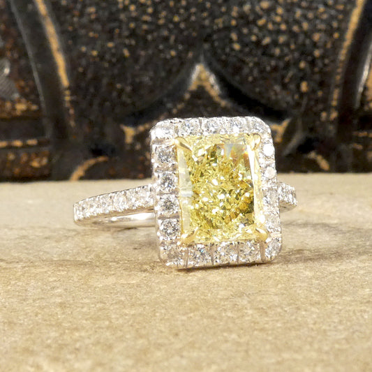Natural Yellow Radiant Cut Diamond with GIA grading in a four claw setting. Surrounded by a halo of bright white Diamonds and Diamond set shoulders in 18ct White Gold. Perfect engagement ring.
