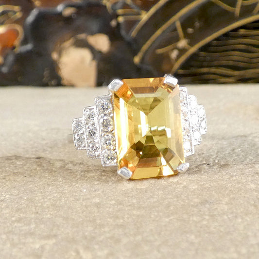 Ring with a large yellow gemstone and smaller diamonds on a textured surface