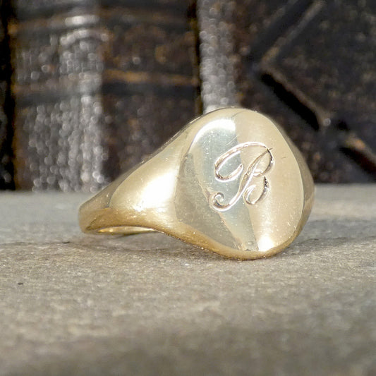 Gold ring with a monogram on a textured surface
