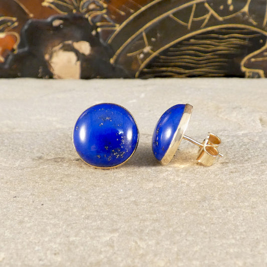 a pair of large blue Lapis Lazuli stud earrings in 9ct yellow gold, shown one from the front and one from the side.