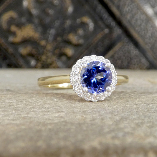 Gold ring with a blue gemstone and diamond accents on a textured surface
