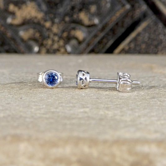 Silver ring and earrings with blue gemstone on a textured surface