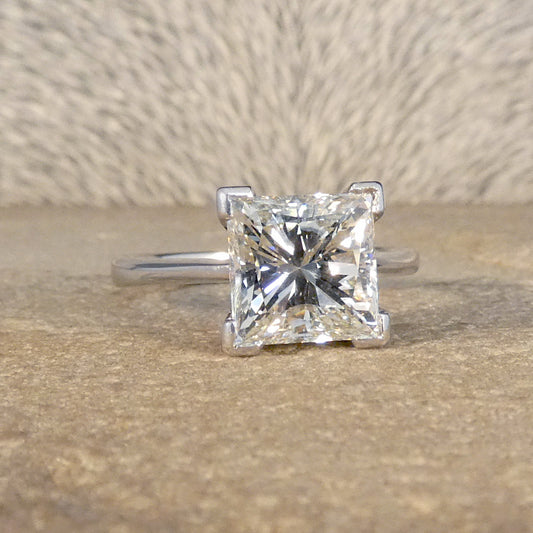 The perfect engagement ring in 18ct White Gold with a central 2.95ct Princess Cut Diamond in a four corner claw setting.