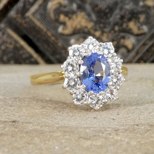 Gold ring with a blue gemstone and diamond accents on a wooden surface.