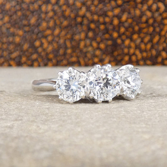 Diamond ring with three stones on a textured surface