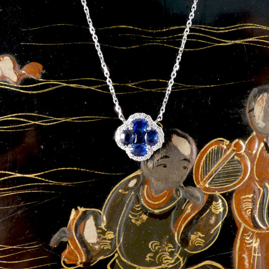 A sapphire clover with a diamond surround on white gold