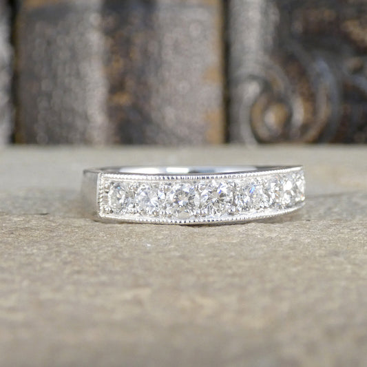 Platinum ring with diamond accents on a textured surface