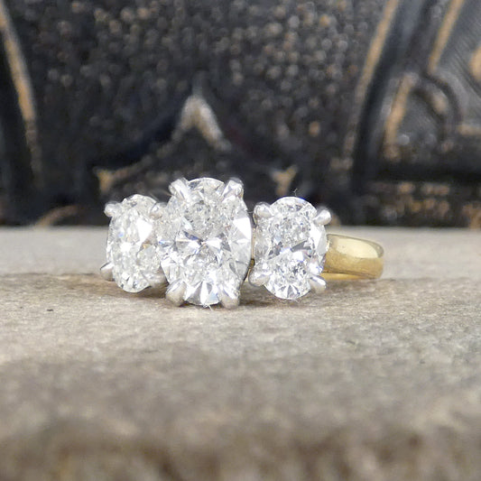 A bright and beautiful diamond three stone ring set with a 1 .00ct Oval cut centre and 0.50ct Oval cut diamonds either side in Platinum with talon claws leading to an 18ct Yellow Gold Band.