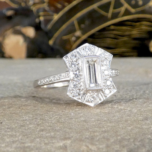 Diamond ring with a rectangular center stone on a textured surface
