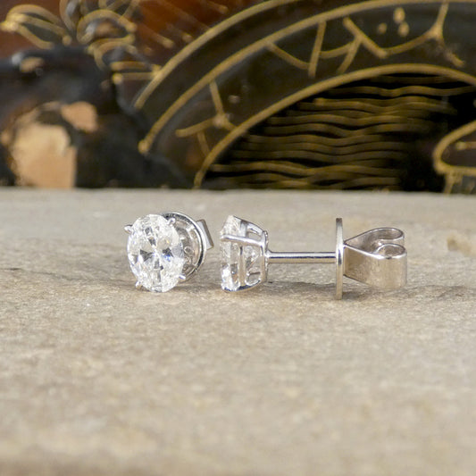 White Gold earrings on a textured surface with a decorative background