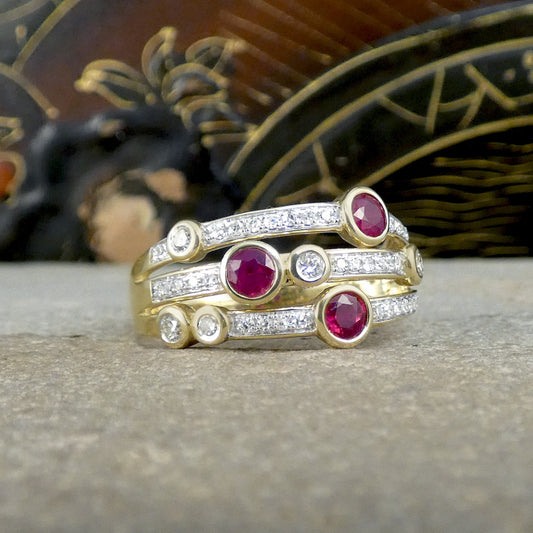 Rubies set into  rub over bezel setting in yellow gold, one on each strand of the bubble ring with Diamonds set the same and further diamond set into the band.