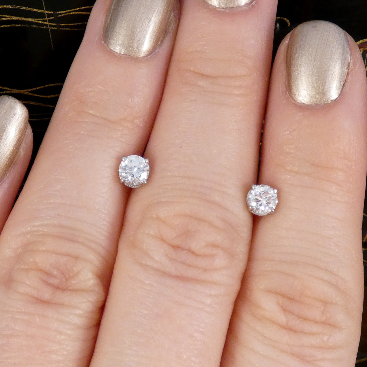 0.61ct Diamond Stud Earrings GIA Certified in 18ct White Gold with a high colour and brilliant cut displayed on the hand to see size ratio.