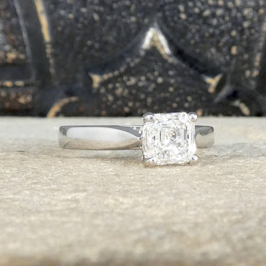 A Squared Emerald Cut Diamond Solitaire Engagement Ring in a four claw setting with a chunky Platinum band and modern feel. Bright Diamond with a GIA certificate.